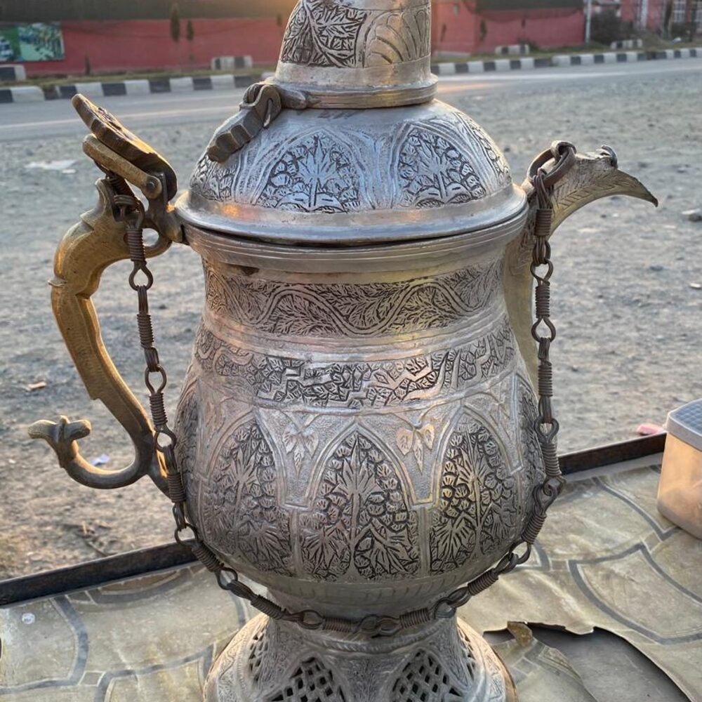 A hand-painted brass kettle used for brewing chai