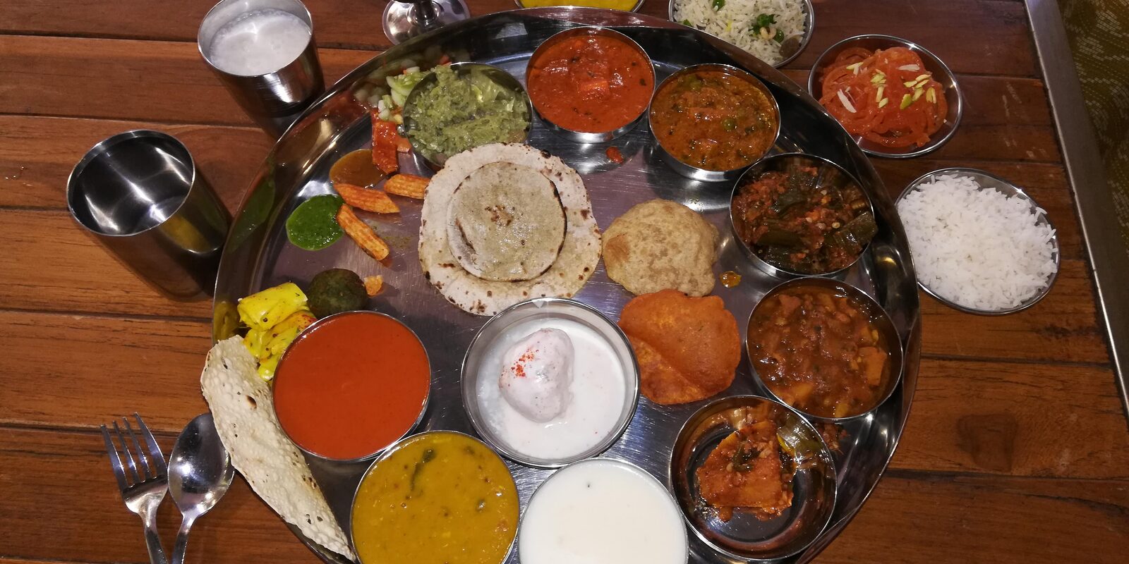 An elaborate thali spread with multiple curries and accompaniments