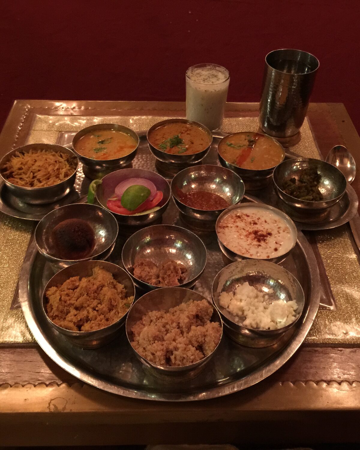 A traditional Rajasthani thali spread with an assortment of small bowls, roti and rice